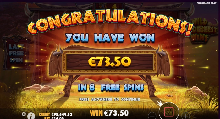 A Wild Wildebeest slot game screen by Pragmatic Play displays a Congratulations! message, indicating a win of €73.50 during 8 free spins, with a credit of €98,649.62 and a bet of €14.00, set against a safari backdrop.
